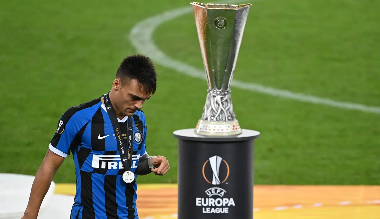 Pemain Inter Milan, Lautaro Martinez, berjalan melewati trofi Liga Europa 2019/2020 di Stadion RheinEenergie, Sabtu (22/8/2020) dini hari WIB. Inter Milan kalah 2-3 atas Sevilla. (AFP/Ina Fassbender/pool)