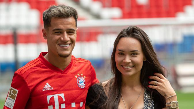 Pemain baru Bayern Munchen Philippe Coutinho (kiri) berpose bersama istrinya Aina Coutinho saat presentasi di Munich, Jerman, Senin (19/8/2019). Pemain asal Barcelona tersebut dipinjam Bayern Munchen selama satu musim. (Peter Kneffel/dpa via AP)