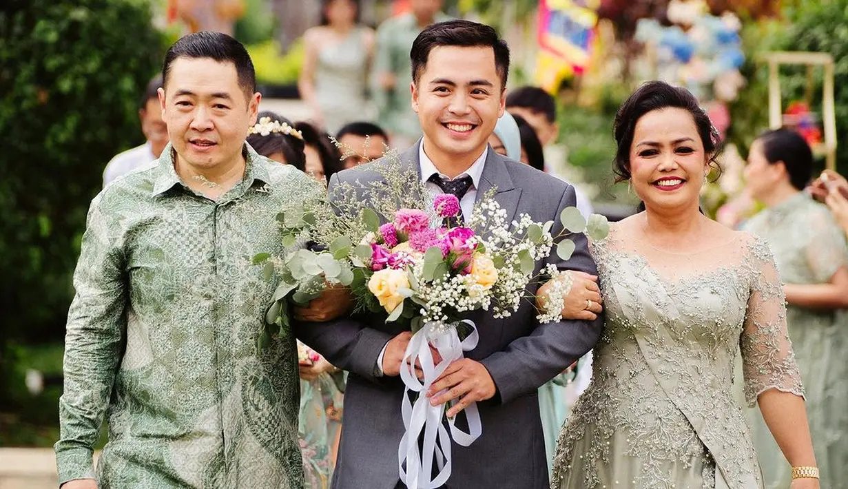 Sedangkan calon suaminya, Arif Hidayat tampak gagah mengenakan jas warna abu-abu. Potret Arif membawa bunga untuk calon istrinya. [Instagram/gritteagathaa]
