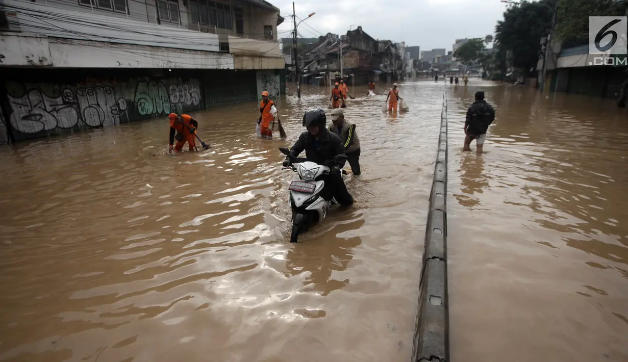 Seorang pengendara motor melintasi banjir di Jalan Jatinegara Barat, Jakarta Timur, Selasa (6/2). Beberapa kendaraan yang nekat melintas akhirnya terpaksa didorong karena mogok. (Liputan6.com/Arya Manggala)