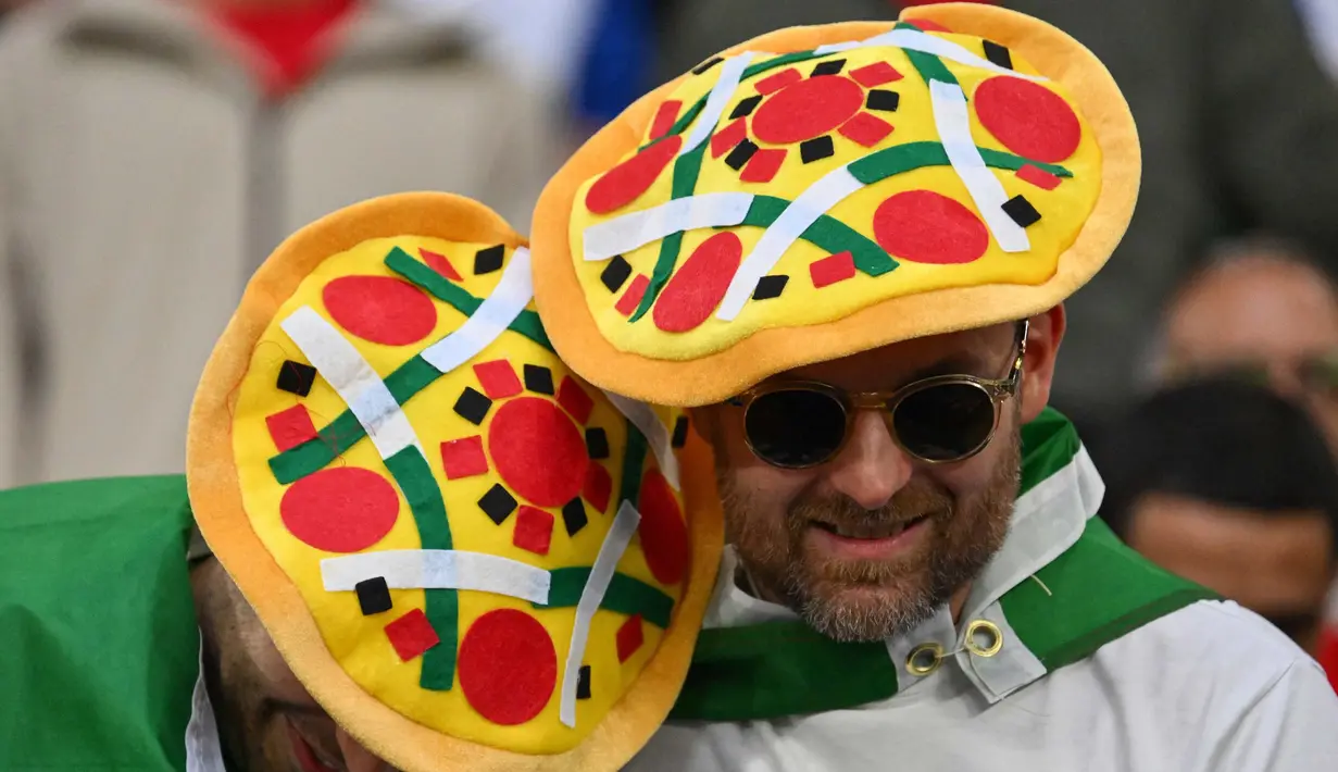 Penggemar Italia yang mengenakan topi pizza menunggu kick off di tengah kerumunan menjelang pertandingan sepak bola Euro 2024 Grup B antara Spanyol dan Italia di Arena AufSchalke, Gelsenkirchen pada 20 Juni 2024. (Alberto PIZZOLI/AFP)