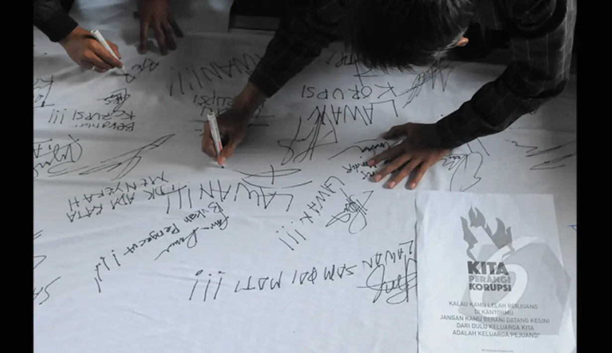 Pegawai KPK menuliskan dukungan unjuk rasa di halaman gedung KPK, Jakarta, Selasa (3/3/2015). Dalam aksinya, pegawai KPK menolak putusan Plt Pimpinan KPK yang melimpahkan kasus Komjen Pol Budi Gunawan ke Kejaksaan Agung. (Liputan6.com/Herman Zakharia)