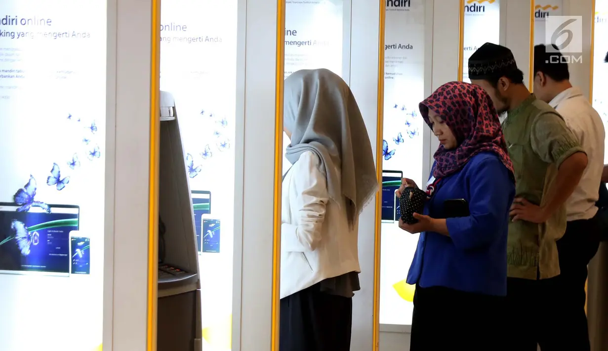 Sejumlah nasabah melakukan transaksi di ATM Mandiri, Jakarta, Selasa (6/6). Jumlah tersebut meningkat sekitar 10 persen dibandingkan kebutuhan uang tunai harian pada bulan-bulan biasanya. (Liputan6.com/Angga Yuniar)