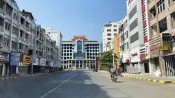 Seorang pria mengendarai sepeda motor di jalan kosong dekat stasiun kereta api di Mandalay, Myanmar, Jumat (10/12/2021). Banyak kantor, toko dan restoran tutup dan orang-orang tinggal di dalam rumah sebagai protes atas pengambilalihan militer ketika aksi mogok senyap atau "silent strike". (AP Photo)