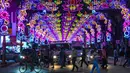 Pejalan kaki menyeberang jalan yang dihiasi dekorasi meriah menjelang Diwali, festival cahaya bagi umat Hindu, di distrik Little India di Singapura pada 23 Oktober 2020. (Photo by Roslan RAHMAN / AFP)