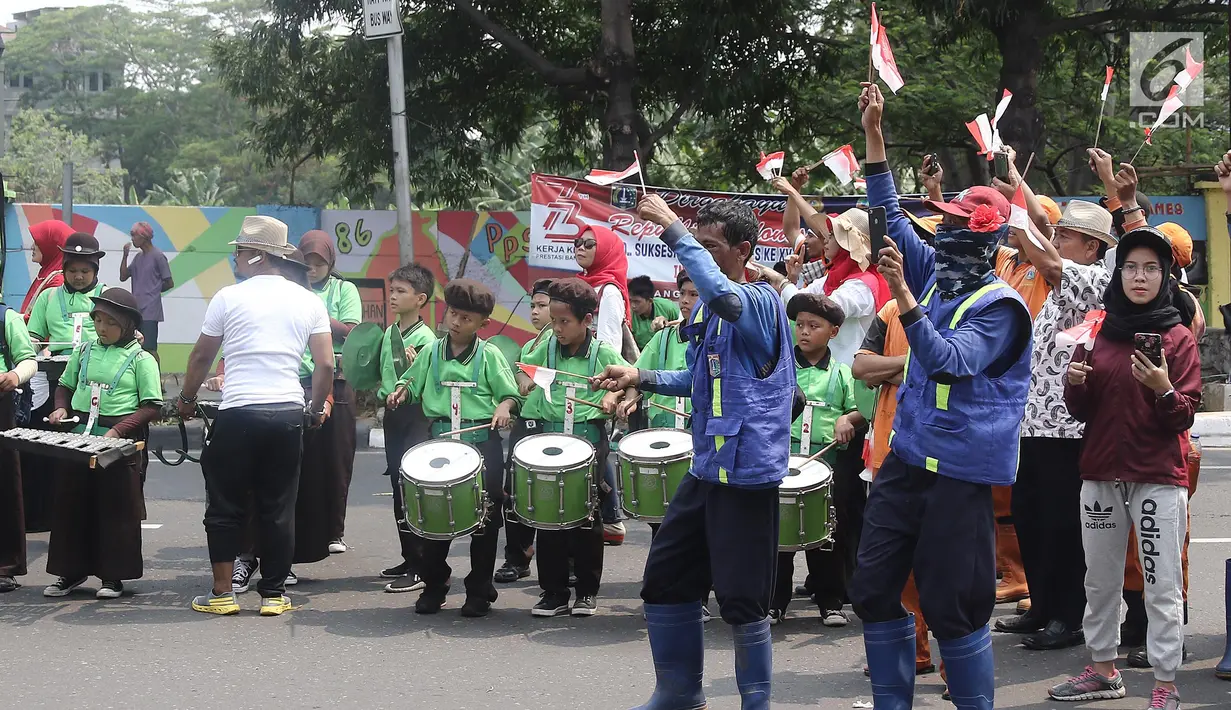 Anak - anak sekolah menyaksikan Torch Relay Asian Games 2018 di kawasan Slipi, Jakarta, Kamis (16/08). Obor Asian Games 2018 tiba di wilayah Jakarta Barat  dan nantinya akan di teruskan berkeliling Jakarta Utara.(Liputan6.com/  Herman Zakharia)