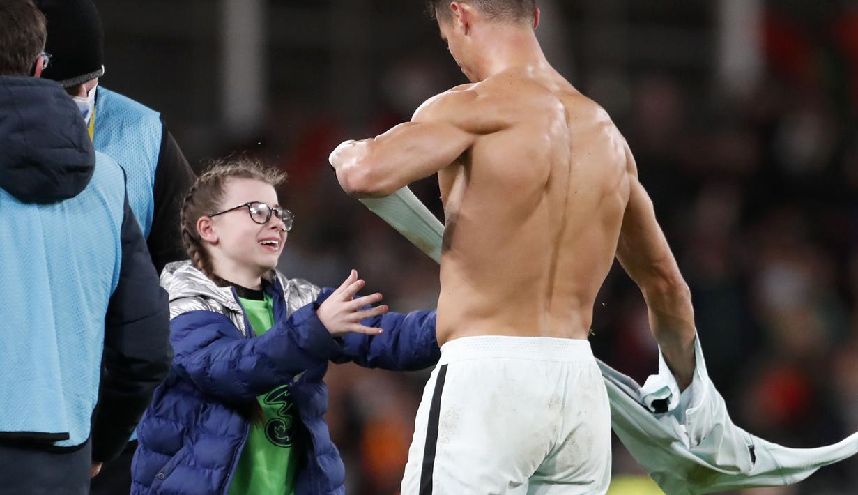 Terlihat bagaimana ekspresi gembira fans cilik Ronaldo tersebut saat akan menerima hadiah dari sang idola. (AP/Peter Morrison)