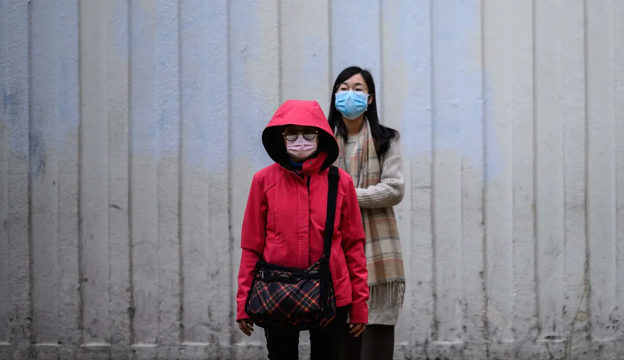 Pejalan kaki mengenakan sungkup muka untuk melindungi diri dari wabah virus corona saat bersiap menyeberang jalan di Hong Kong pada 4 Februari 2020. WHO mengatakan wabah virus corona COVID-19 merupakan ancaman sangat besar bagi seluruh dunia. (Anthony WALLACE/AFP)