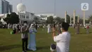 Umat muslim berswafoto usai melaksanakan shalat Idul Fitri 1442 H di Lapangan Masjid Agung Al Azhar, Jakarta, Kamis (13/5/2021). Ribuan umat muslim melaksanakan shalat Idul Fitri 1442 H di Lapangan Masjid Agung Al Azhar dengan menerapkan protokol kesehatan ketat. (Liputan6..com/Helmi Fithriansyah)