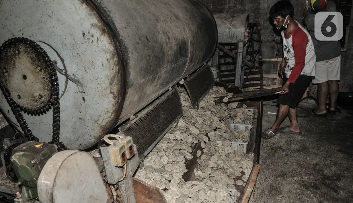 Pekerja menggunakan mesin pemanas saat produksi kerupuk di industri rumahan kawasan Cipinang Melayu, Jakarta, Selasa (16/2/2021). Irwan (42), pemilik industri kerupuk itu mengungkapkan akibat pandemi Covid-19 yang berkepanjangan menyebabkan penjualan kerupuk anjlok. (merdeka.com/Iqbal S Nugroho)