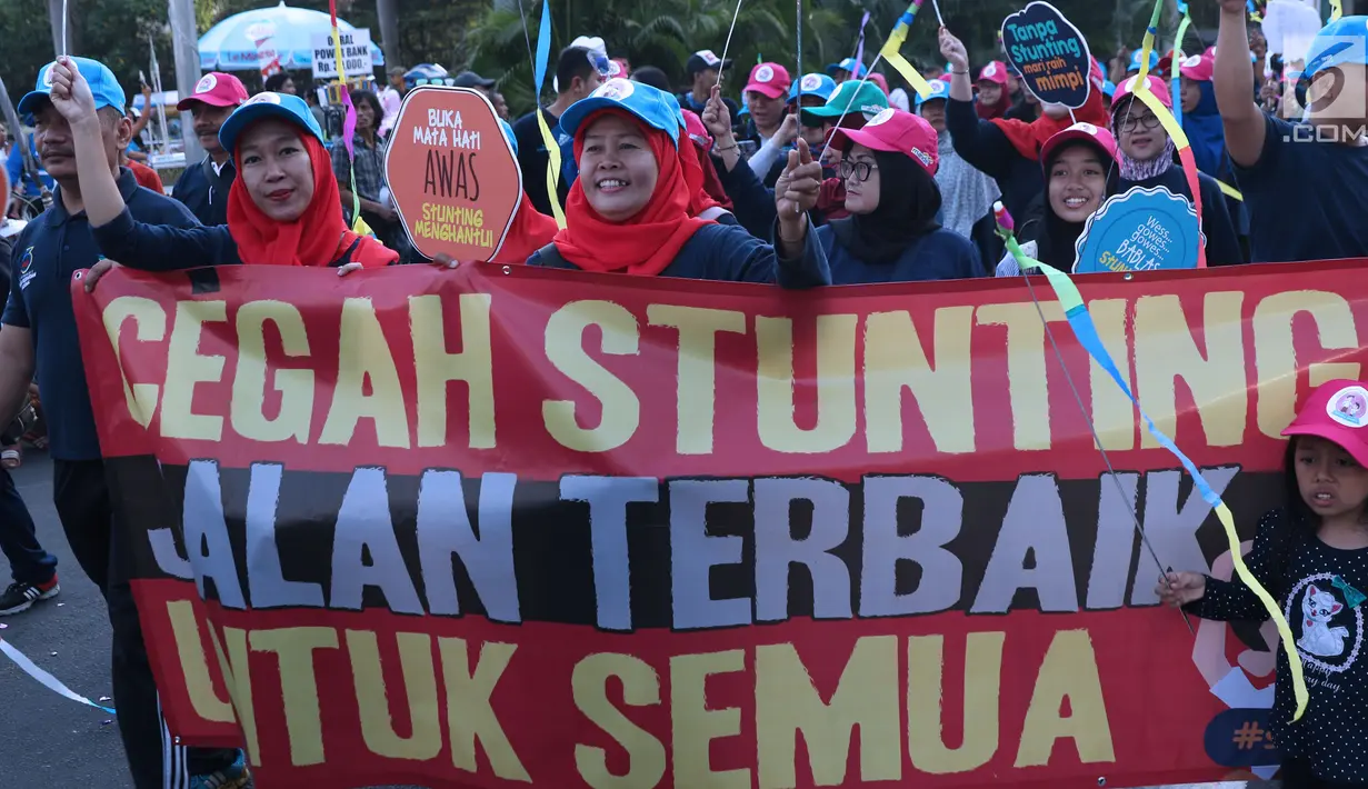 Peserta kampanye cegah stunting membawa spanduk saat berjalan di kawasan Bundaran Hotel Indonesia, Jakarta, Minggu (16/9). Peserta juga bakal memberikan penyuluhan tentang stunting ke masyarakat sekitar. (Liputan6.com/Helmi Fithriansyah)