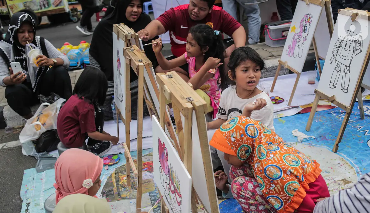 Anak-anak mewarnai gambar saat car free day (CFD) di kawasan Bundaran HI, Jakarta, Minggu (27/10/2019). Kegiatan tersebut digelar untuk melatih keterampilan motorik halus serta mengembangkan kreativitas dan imajinasi pada anak. (Liputan6.com/ Faizal Fanani)