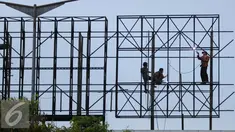 Pekerja menyelesaikan pembuatan papan reklame di jalan Gadjah Mada, Jakarta, Selasa (13/12). Pemerintah DKI Jakarta akan menyusun rencana penataan terhadap reklame yang tidak beraturan di jalur protokol. (Liputan6.com/Gempur M. Surya)