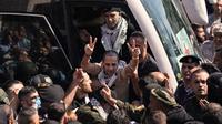Seorang tahanan Palestina mengangkat tangan dengan tanda kemenangan saat tiba di Ramallah, Tepi Barat, setelah dibebaskan dari penjara Israel dalam kesepakatan gencatan senjata antara Israel dan Hamas, Senin (13/10/2025). (Dok. AP Photo/Majdi Mohammed)