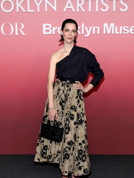 Rebecca Hall mengenakan kemeja katun hitam Dior Spring-Summer 2024
dan rok katun bermotif. Dia juga mengenakan tas dan sepatu Dior. {Dior]