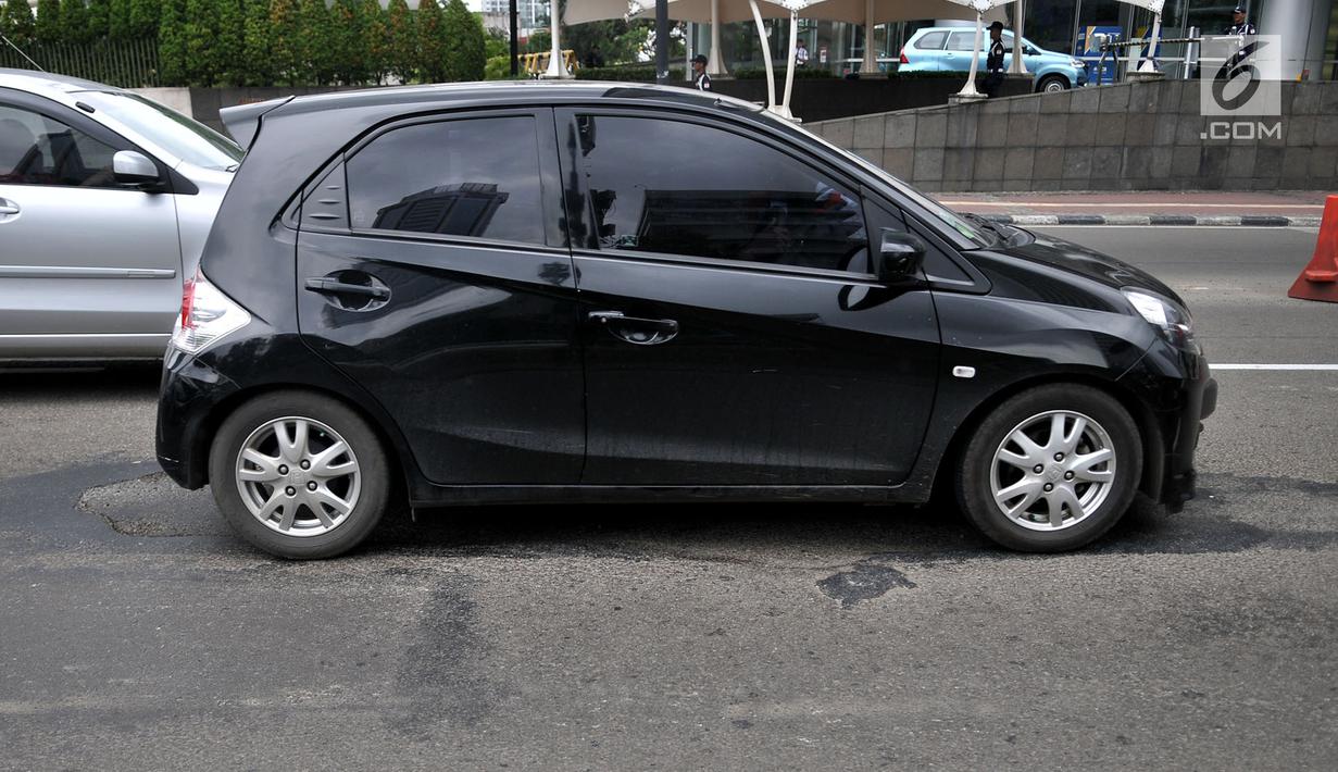 Kendaraan melintas di dekat jalan berlubang di Jalan Jenderal Sudirman, Jakarta, Senin (11/3). Minimnya perawatan dan pengawasan membuat jalan tersebut berlubang hingga kedalaman 10 sentimeter. (merdeka.com/Iqbal S. Nugroho)