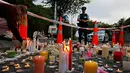 Seorang pelajar menyalakan lilin saat mengenang korban penembakan di luar Masjid Al Noor, Christchurch, Selandia Baru, Senin (18/3). Sebanyak 50 orang tewas dalam insiden tersebut. (AP Photo/Vincent Yu)