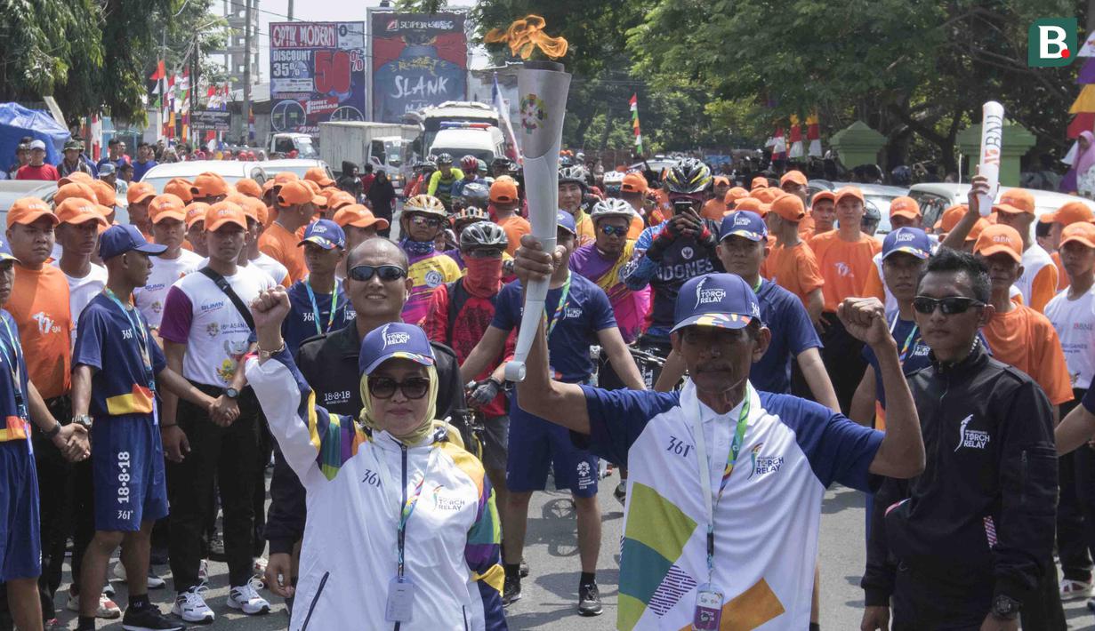Pebalap sepeda legendaris Indonesia, Sutiyono, bersiap mengikuti pawai obor Asian Games XVIII di Lampung, Rabu (8/8/2018). Sebanyak 53 kota di Indonesia akan dilalui oleh obor Asian Games. (Bola.com/Reza Bachtiar)