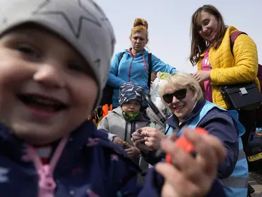 Pengungsi Olga bersama anak-anaknya berangkat menuju Pokrovsk, Wilayah Donetsk, Ukraina dari perbatasan di Medyka, Polandia, Rabu (30/3/2022). Menyusul pengumuman Rusia bahwa pasukan mungkin ditarik dari berbagai bagian Ukraina, beberapa pengungsi kembali ke negaranya. (AP Photo/Sergei Grits)