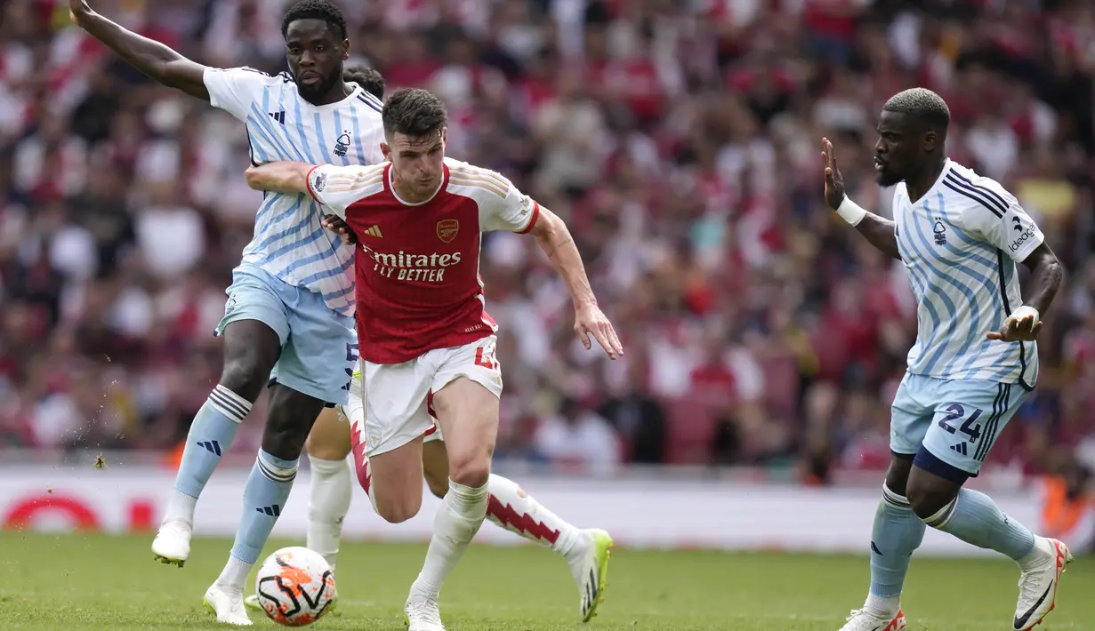 Pemain Arsenal, Declan Rice (tengah), berusaha melewati hadangan pemain Nottingham Forest di pekan pertama Premier League 2023/2024 yang berlangsung di Emirates Stadium, Sabtu (12/8/2023) malam WIB. (AP Photo/Kirsty Wigglesworth)