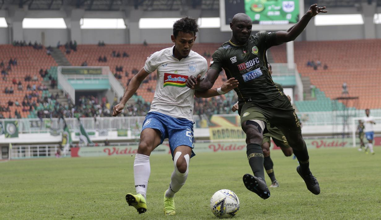 Striker PSIS Semarang, Hari Nur, berebut bola dengan bek Tira Persikabo, Mountala Zoubairou, pada laga Shopee Liga 1 di Stadion Pakansari, Bogor, Jumat (22/11). PSIS menang 2-1 atas Tira Persikabo. (Bola.com/Yoppy Renato)