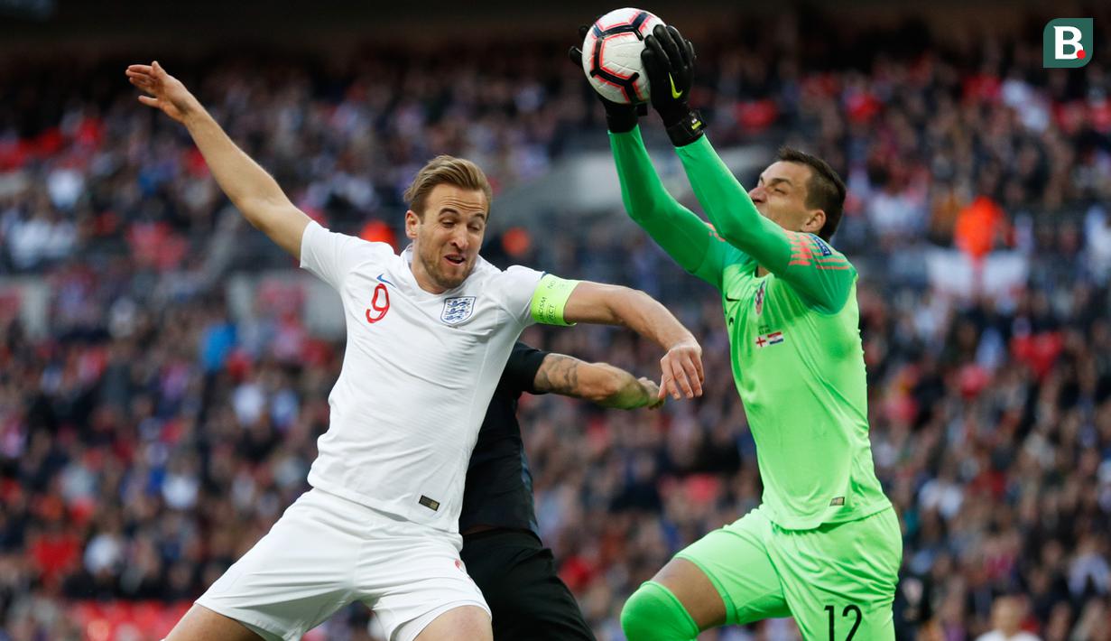 Striker Inggris, Harry Kane, berebut bola dengan kiper Kroasia, Lovre Kalinic, pada laga UEFA Nations League di Stadion Wembley, London, Minggu (18/11). Inggris menang 2-1 atas Kroasia. (AFP/Adrian Dennis)