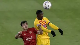 Bek Osasuna, Manu Sanchez (kiri) berduel udara dengan striker Barcelona, Ousmane Dembele dalam laga lanjutan Liga Spanyol 2020/21 pekan ke-26 di El Sadar Stadium, Pamplona, Sabtu (6/3/2021). Osasuna kalah 0-2 dari Barcelona. (AP/Alvaro Barrientos)