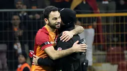 Pemain Galatasaray, Yasin Oztekin memeluk petugas polisi setelah mencetak gol saat melawan Gaziantepspor dalam Liga Super Turki di Istanbul, Minggu (11/12). Itu dilakukan Oztekin sebagai ungkapan duka cita atas tragedi ledakan bom Besiktas (AFP PHOTO/STR)