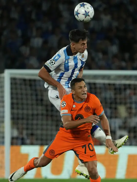 Gelandang Real Sociedad #04 Martin Zubimendi melakukan sundulan saat bersaing dengan penyerang Inter Milan #70 Alexis Sanchez pada laga matchday 1 Grup D Liga Champions 2023/2024 yang digelar di Reale Arena, Kamis (21/9/2023) dini hari WIB. (Photo by CESAR MANSO / AFP)