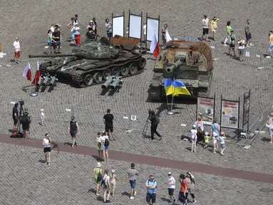 Orang-orang mengunjungi pameran terbuka tank dan kendaraan lapis baja Rusia yang rusak dan terbakar di Castle Square, di Warsawa, Polandia (27/6/2022). Kendaraan tersebut ditangkap oleh pasukan militer Ukraina selama perang di Ukraina. (AP Photo/Michal Dyjuk)