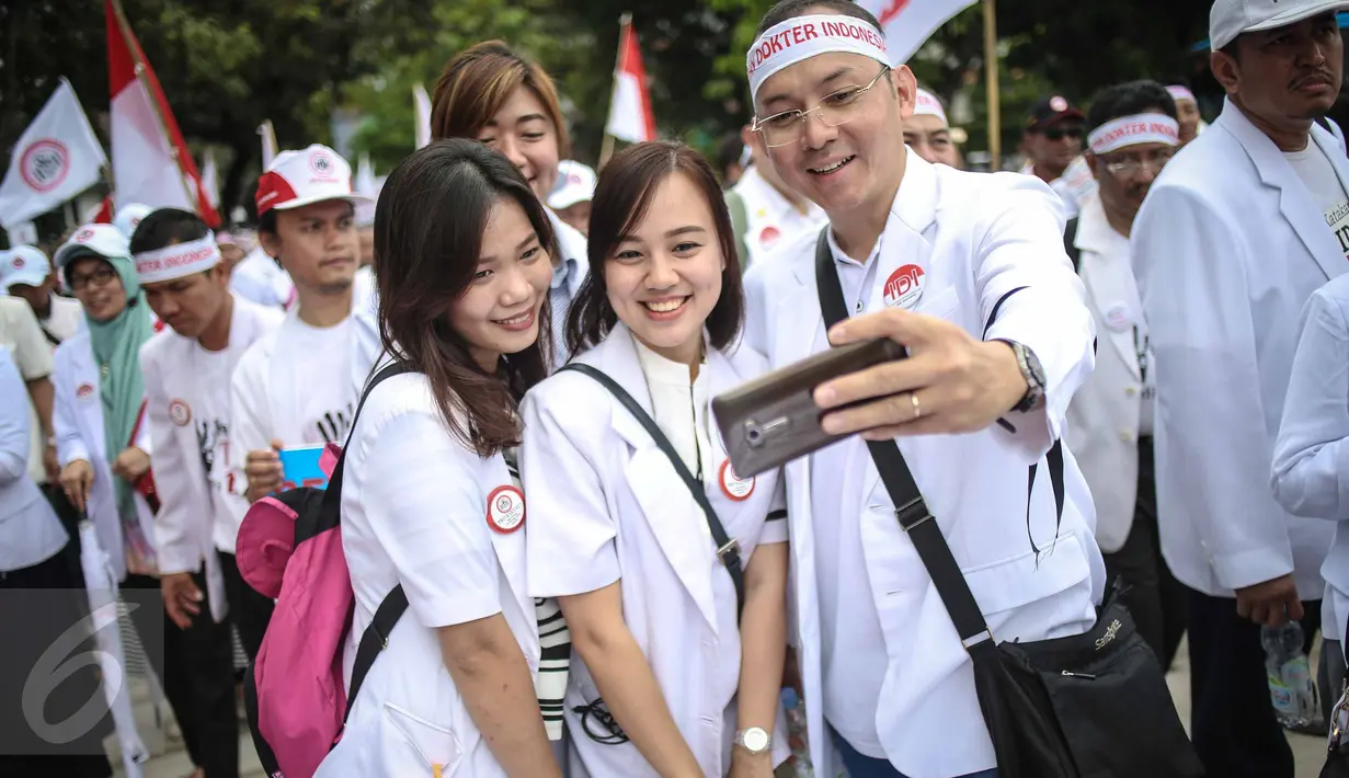 Sejumlah dokter berselfie saat melakukan aksi unjuk rasa di Ibu Kota hari ini, Senin (24/10). Demo itu untuk menuntut pemerintah agar membatalkan Program Dokter Layanan Primer (DLP). (Liputan6.com/Faizal Fanani)