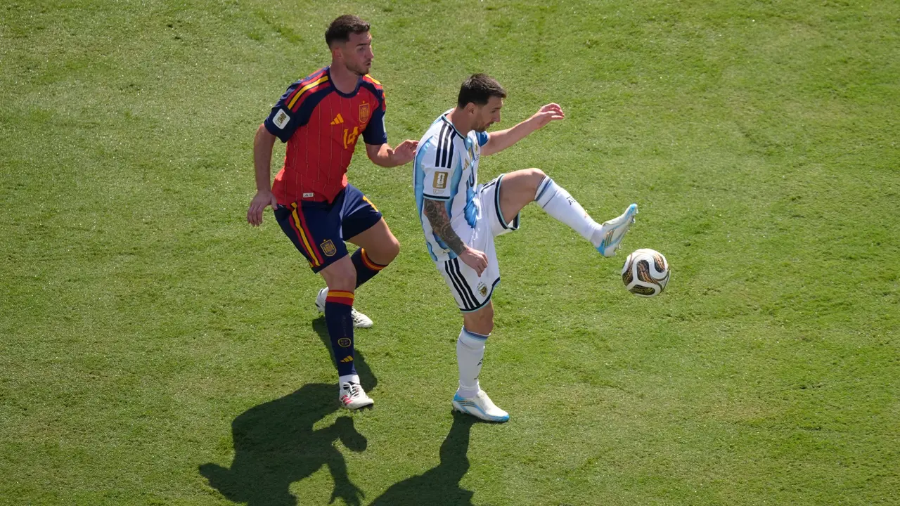 Pemain Spanyol Aymeric Laporte (kiri) mengawal pemain Argentina Lionel Messi