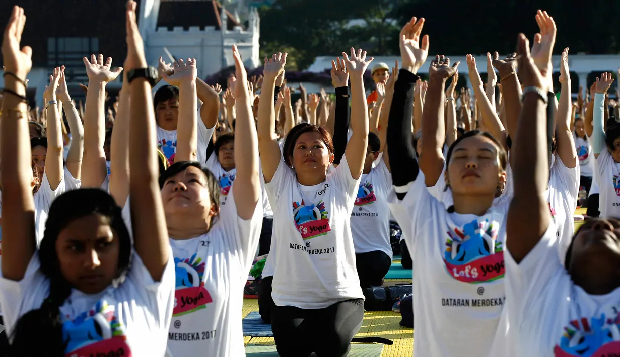 Sejumlah peserta mengikuti latihan yoga di Lapangan Independen di Kuala Lumpur, Malaysia (2/7). Acara yang merupakan perayaan Hari Yoga Sedunia dihadiri oleh Wakil Menteri Wilayah Persekutuan, Datuk Loga Bala Mohan. (AP Photo / Daniel Chan)