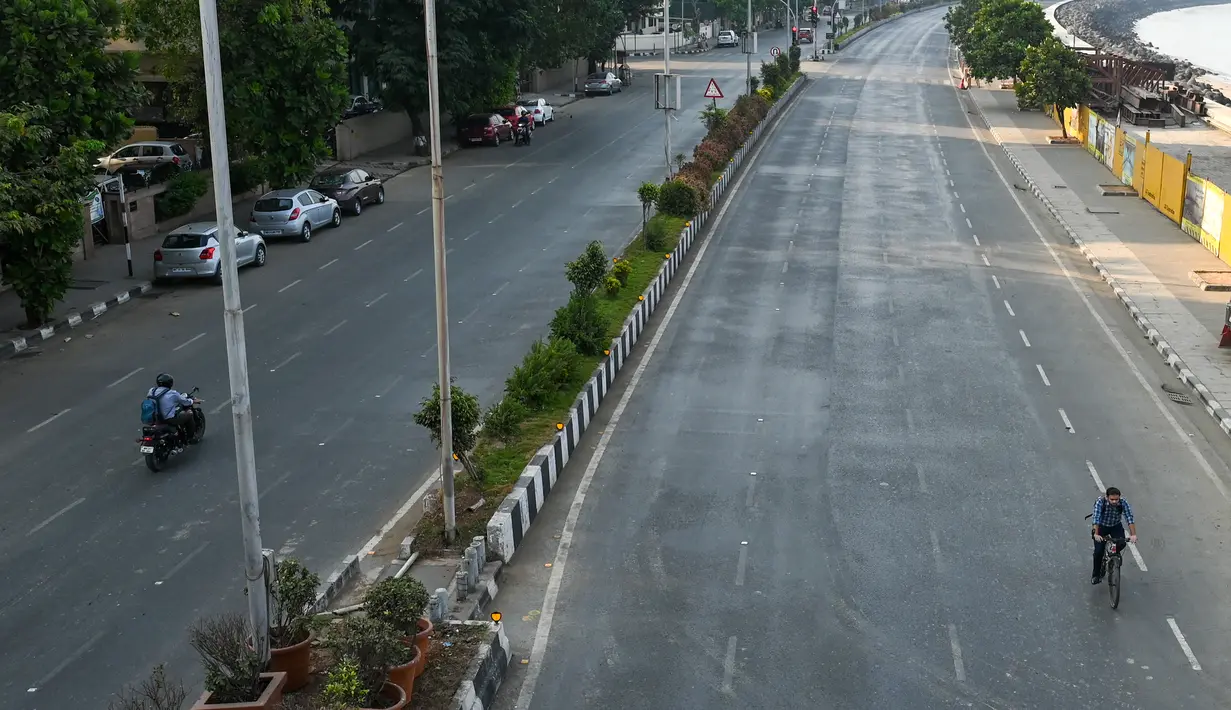 Jalan sepi di Marine Drive terlihat selama pembatasan yang diberlakukan oleh pemerintah negara bagian di tengah meningkatnya kasus corona Covid-19, di Mumbai, Kamis (15/4/2021). Kasus virus corona baru di India mencapai rekor tertinggi pada Rabu, 14 April. (Punit PARANJPE / AFP)