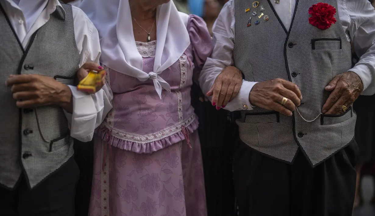 Orang-orang yang mengenakan pakaian tradisional 'chulapo' menari selama perayaan San Cayetano, santo pelindung tenaga kerja dan roti, di lingkungan Lavapies di Madrid, Spanyol, Sabtu (6/8/2022). Festival San Cayetano menandai awal dari serangkaian festival populer di Madrid. (AP Photo/Manu Fernandez)