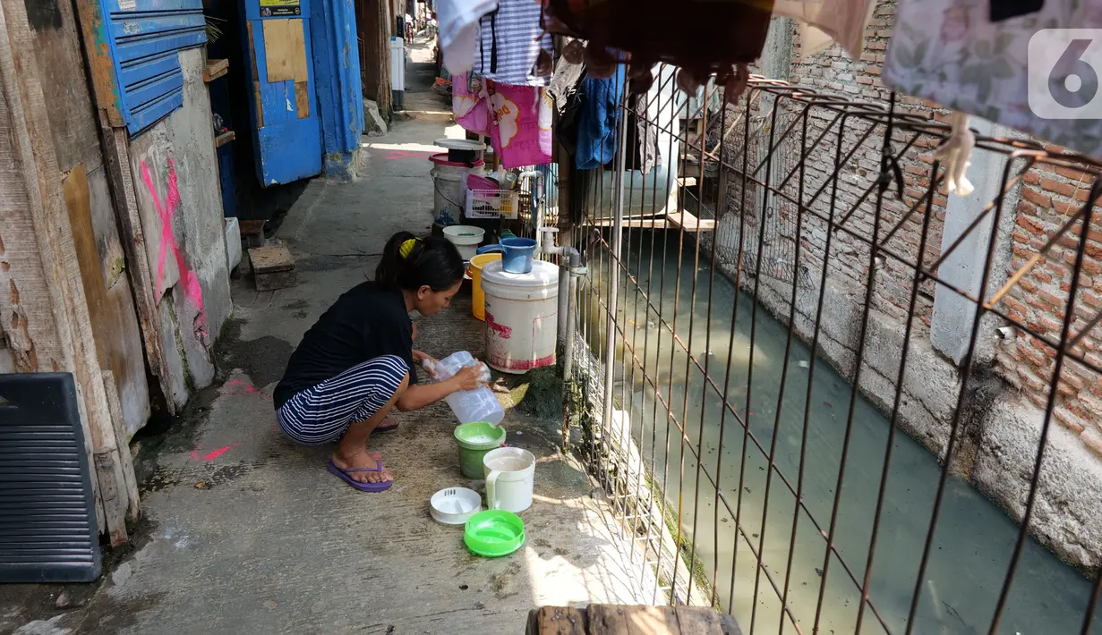 Warga mencuci peralatan dapur di belakang rumahnya yang berada di Gang Sekretaris, RT 015/RW 007 Tanjung Duren Utara, Jakarta Barat , Selasa (8/10/2019). Warga di kawasan tersebut tidak memiliki septic tank sehingga hajat yang dibuang langsung mengalir ke kali. (Liputan6.com/Herman Zakharia)