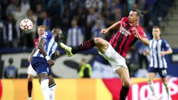 Pemain AC Milan Zlatan Ibrahimovic berebut bola dengan pemain Porto Chancel Mbemba (kiri) pada pertandingan sepak bola Grup B Liga Champions di Stadion Dragao, Porto, Portugal, Selasa (19/10/2021). Porto menang 1-0. (AP Photo/Luis Vieira)