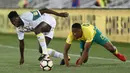 Bek Senegal, Lamine Gassama, berebut bola dengan gelandang Afrika Selatan, Sibusiso Vilakazi, pada laga kualifikasi Piala Dunia 2018 di Stadion The Peter Mokaba, Jumat (10/11/2017). Senegal menang 2-0 atas Afrika Selatan. (AFP/Phill Magakoe)