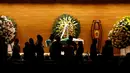 Sejumlah pelayat berbincang didekat jenazah mantan pemain sepak bola Brasil, Carlos Alberto yang sedang disemayamkan di di Konfederasi Sepakbola Brasil (CBF) di Rio de Janeiro, Brasil (25/10). (Reuters/ Ricardo Moraes)