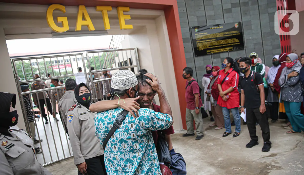 Seorang pengunjuk rasa yang menolak UU Cipta Kerja memeluk orang tuanya di Polda Metro Jaya, Jakarta, Rabu (14/10/2020). Mereka diamankan petugas Kepolisian karena diduga terlibat kericuhan saat unjuk rasa menolak UU Cipta Kerja pada Selasa (14/10/2020). (Liputan6.com/Faizal Fanani)