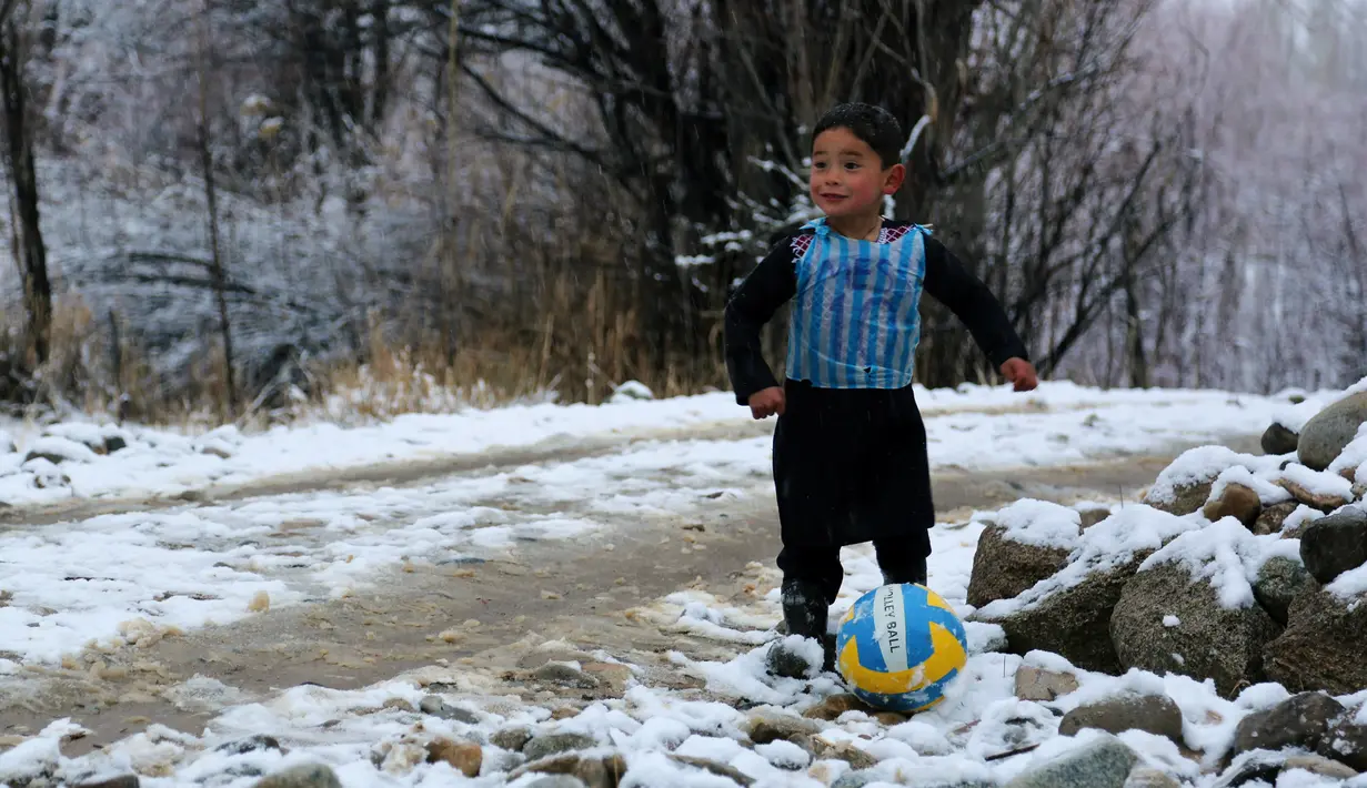 Murtaza Ahmadi, anak laki-laki Afghanistan, bermain bola sambil mengenakan kaos kantong kresek timnas Argentina milik Lionel Messi di  kabupaten Jaghori, provinsi Ghazni, 29 Januari 2016. Sebelumnya, foto Murtaza itu menyebar luas di dunia maya (STR/AFP)
