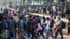 Sejumlah penumpang Comuter Line menyebrang antar peron di Stasiun Manggarai, Jakarta, Selasa (28/3). Stasiun Manggarai dipadati penumpang yang hendak berlibur pada Hari Raya Nyepi Tahun Baru Saka 1939. (Liputan6.com/Faizal Fanani)