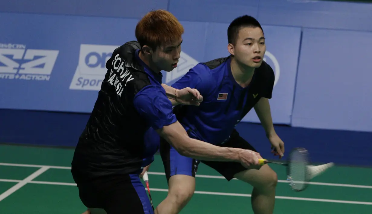 Ganda putra Malaysia, Aaron Chia / Soh Wooi Yik, mengembalikan kok saat melawan Fajar Rian / Muhammad Rian, pada final beregu SEA Games 2019 di Multinlupa Sport Center, Rabu (4/12). Fajar / Rian kalah 17-21 dan 13-21. (Bola.com/M Iqbal Ichsan)