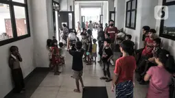 Anak-anak bermain di lorong kelas saat mengungsi di SDN 01 Kampung Melayu, Jakarta, Minggu (21/2/2021). Sudah 2 hari ratusan warga dari 4 RW di Kelurahan Kampung Melayu mengungsi di gedung sekolah lantaran banjir yang merendam rumah mereka tak kunjung surut. (merdeka.com/Iqbal S Nugroho)