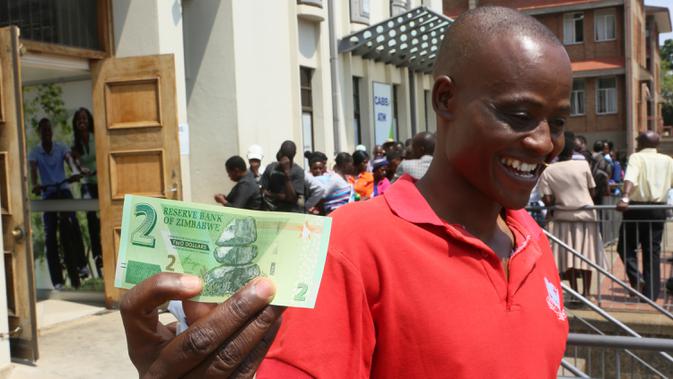 Seorang pria menunjukkan salah satu uang kertas baru yang dikeluarkan Reserve Bank of Zimbabwe di Harare, 12 November 2019. Pemerintah Zimbabwe memperkenalkan kembali mata uang negaranya setelah hampir sedekade terakhir menggunakan mata uang negara lain untuk bertransaksi. (AP/Tsvangirayi Mukwazhi)