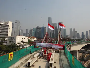 Pekerja melakukan pengecoran tahap akhir jembatan lengkung bentang panjang atau long span pada proyek LRT Jabodebek di kawasan Kuningan, Jakarta, Senin (11/11/2019). Long span tersebut menjadi yang terpanjang di dunia. (Liputan6.com/Angga Yuniar)