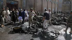 Sejumlah pria memindahkan bangkai motor yang hangus terbakar dalam ledakan bom di luar sebuah masjid bersejarah di kota Herat, Afghanistan, Selasa (6/6). Ledakan ini menyebabkan tujuh orang tewas dan 15 lainnya terluka. (AP Photos/Hamed Sarfarazi)