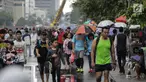 Warga melakukan olahraga dalam kegiatan rutin hari bebas kendaraan bermotor atau car free day di kawasan Bunderan HI, Jakarta, Minggu (4/2). Walaupun gerimis mengguyur tidak menyurutkan minat masyarakat yang melakukan olahraga.(Liputan6.com/Faizal Fanani)