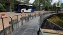 Bus Transjakarta melintas dekat fasilitas pejalan kaki di Taman Semanggi, Jakarta, Rabu (12/10/2022). Gubernur DKI Jakarta Anies Baswedan menyatakan pembangunan fasilitas pejalan kaki dan jalur sepeda itu bertujuan untuk memberikan ruang interaksi dan oase baru bagi warga Ibu Kota dan sekitarnya. (Liputan6.com/Herman Zakharia)