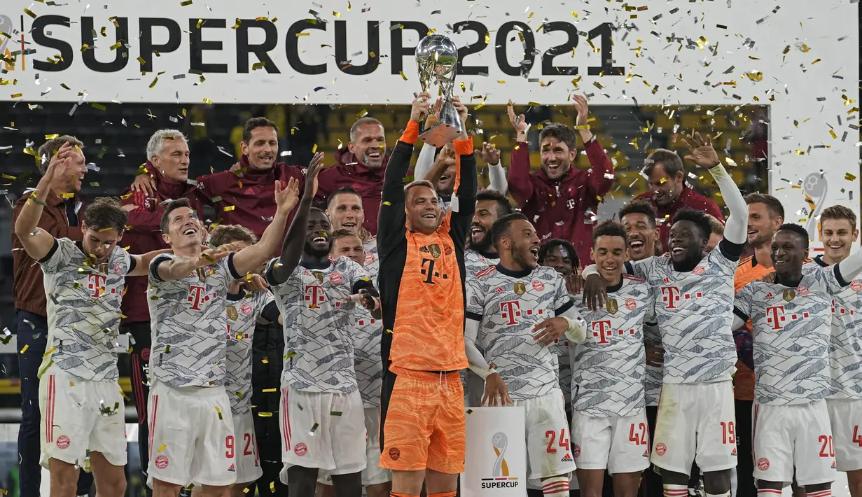 Kiper Bayern Manuel Neuer memegang trofi di depan timnya setelah memenangkan pertandingan Supercup Jerman melawan Borussia Dortmund di Signal Iduna Park Dortmund, Jerman, Rabu (18/8/2021). Munchen berhasil meraih gelar Piala Super Jerman usai mengalahkan atas Dortmund 3-1. (AP Photo/Martin Meissner)